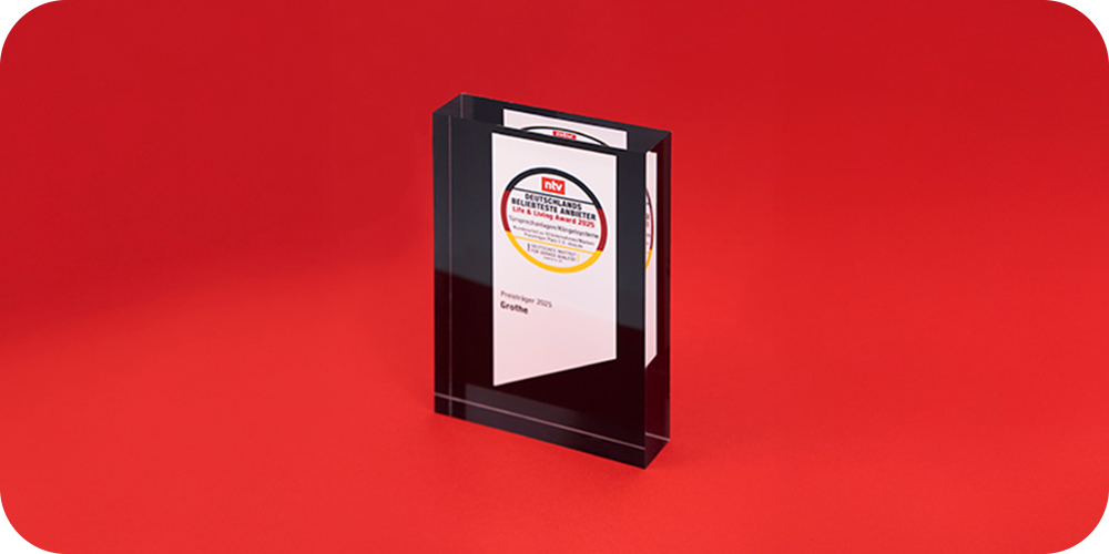 Der Life & Living Award für Grothe steht vor einem roten Hintergrund