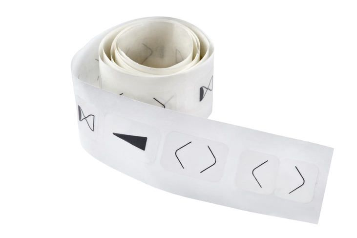 Rolle doppelseitiges Klebeband mit vorgestanzten Symbolen auf transparenter Trägerfolie zur Markierung von Tastern