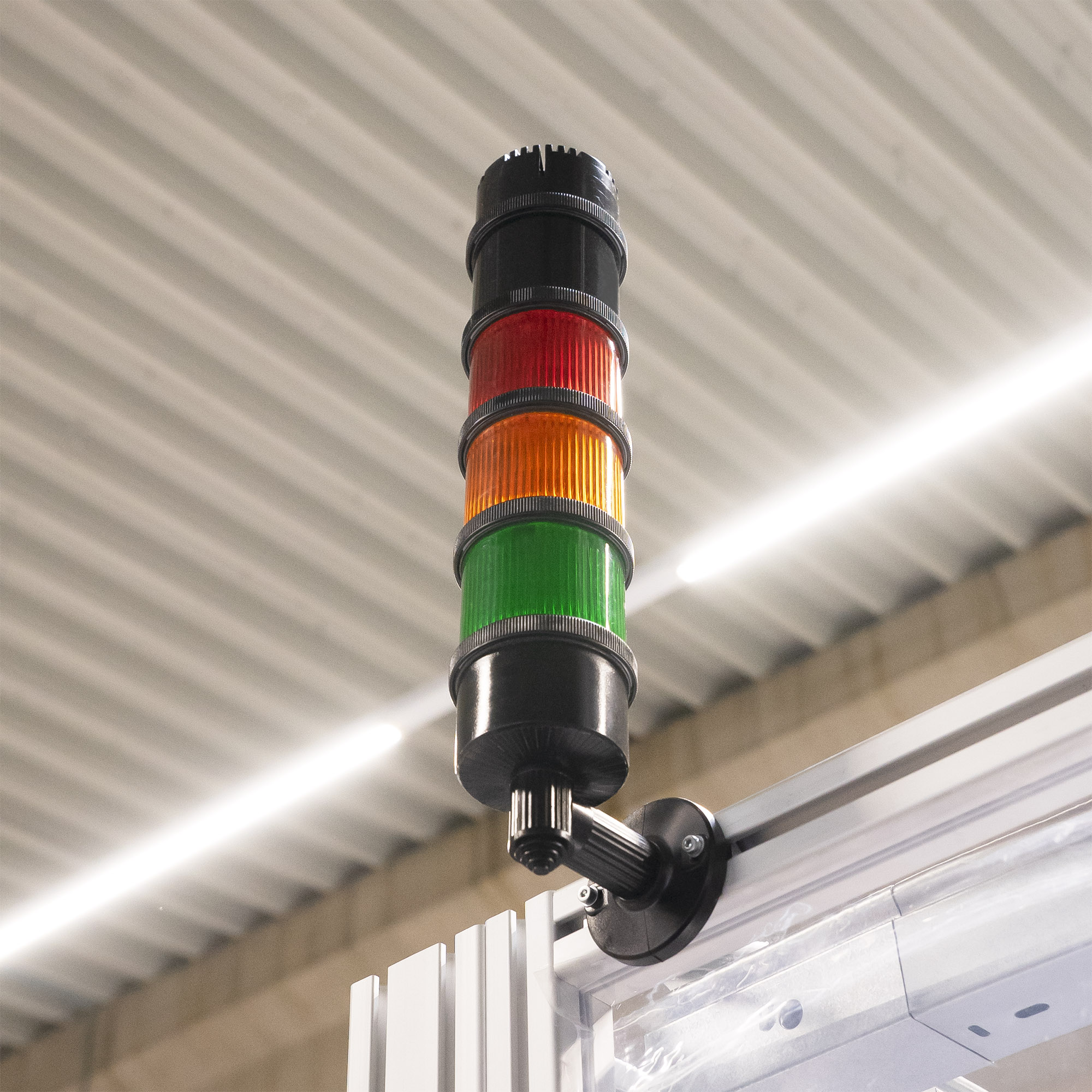 Zylindrische LED-Blinkleuchte mit geriffelter orangefarbener Abdeckung, schwarzem Sockel und grauem Anschlussgehäuse