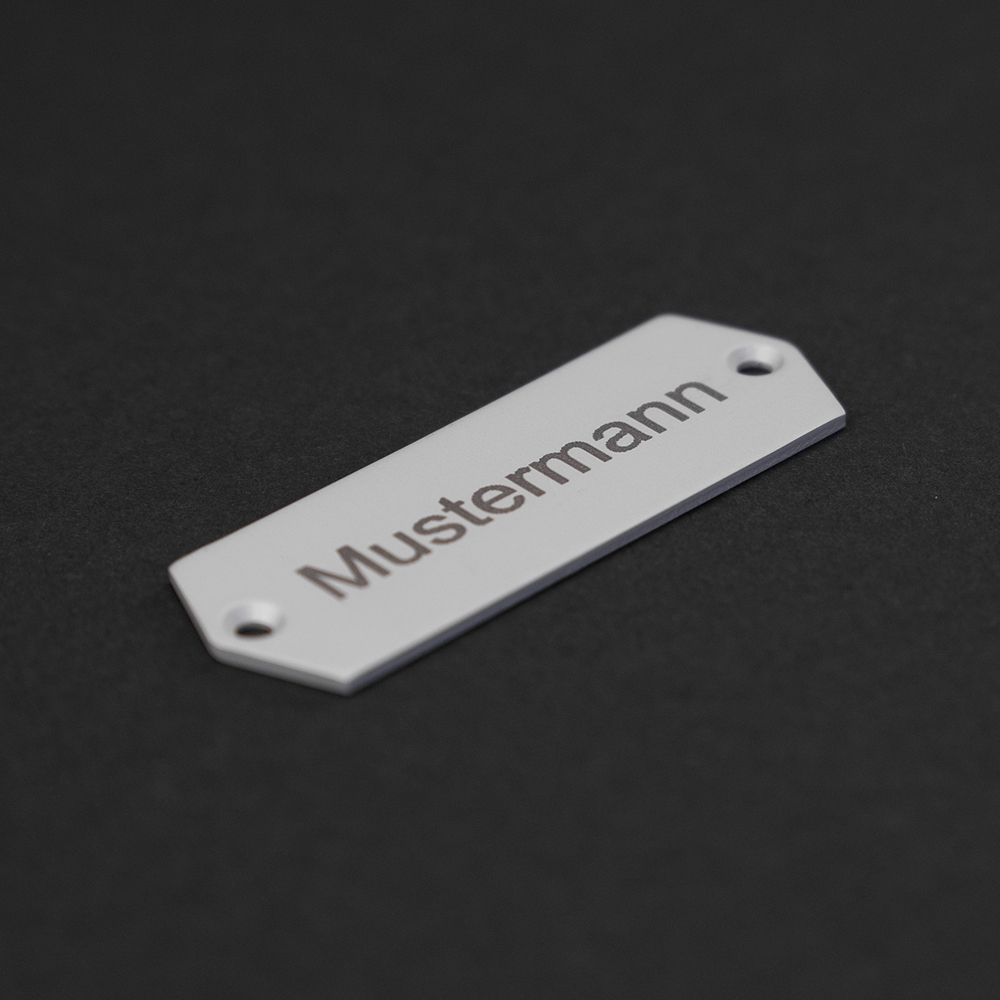 Edelstahl-Gravierschild seitlich liegend; darauf steht "Mustermann"