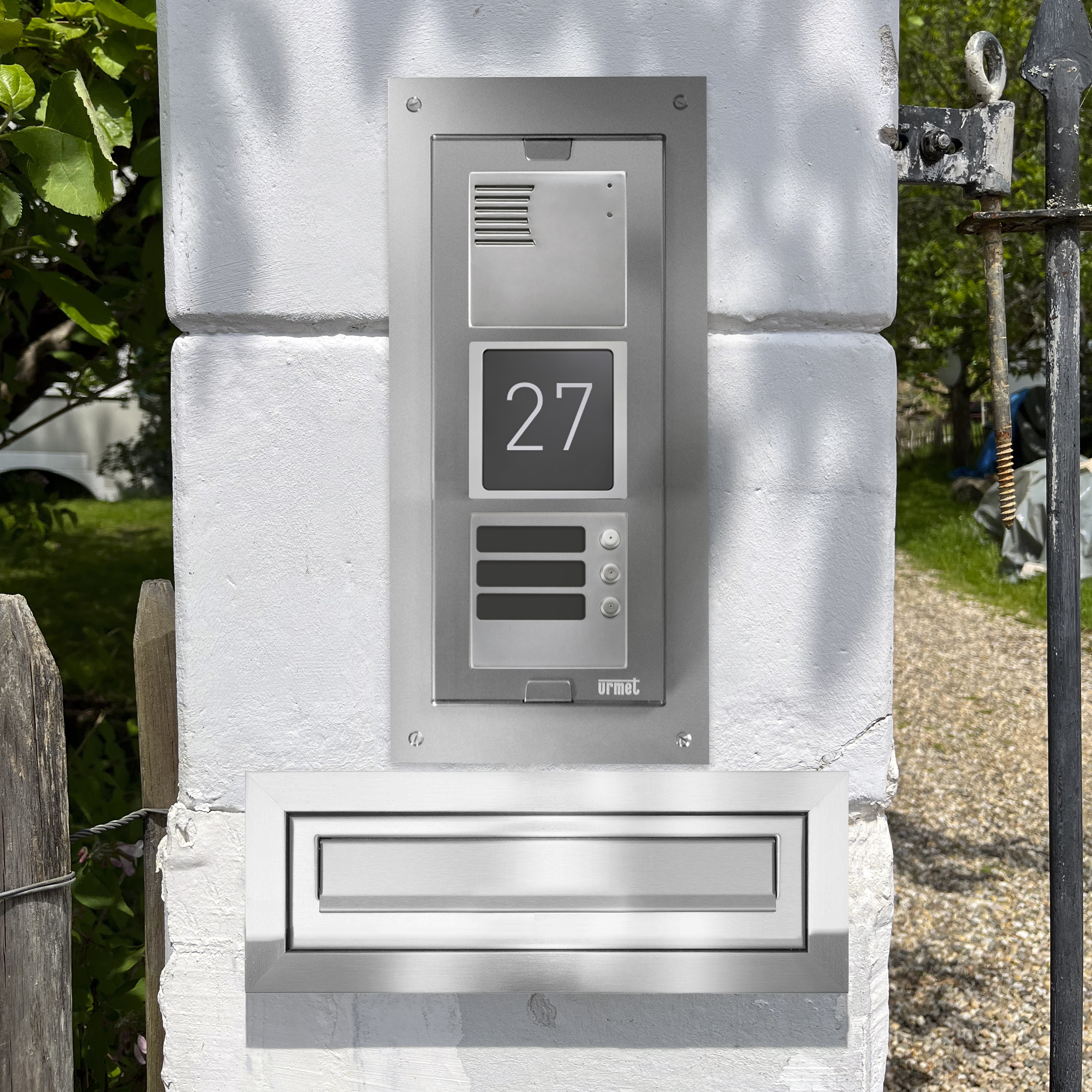 ELEKTA Türstation, eingebaut in eine gemauerte Säule vor einem Vorgarten, in einem Rahmen und über einem Briefkastenschlitz