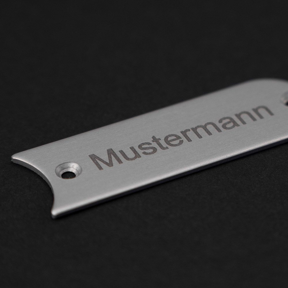 Edelstahl-Gravierschild seitlich liegend; darauf steht "Mustermann"