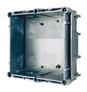 Rechteckiges Unterputz-Gehäuse aus Kunststoff mit seitlichen Öffnungen und Montagelöchern, schräg aufgenommen.