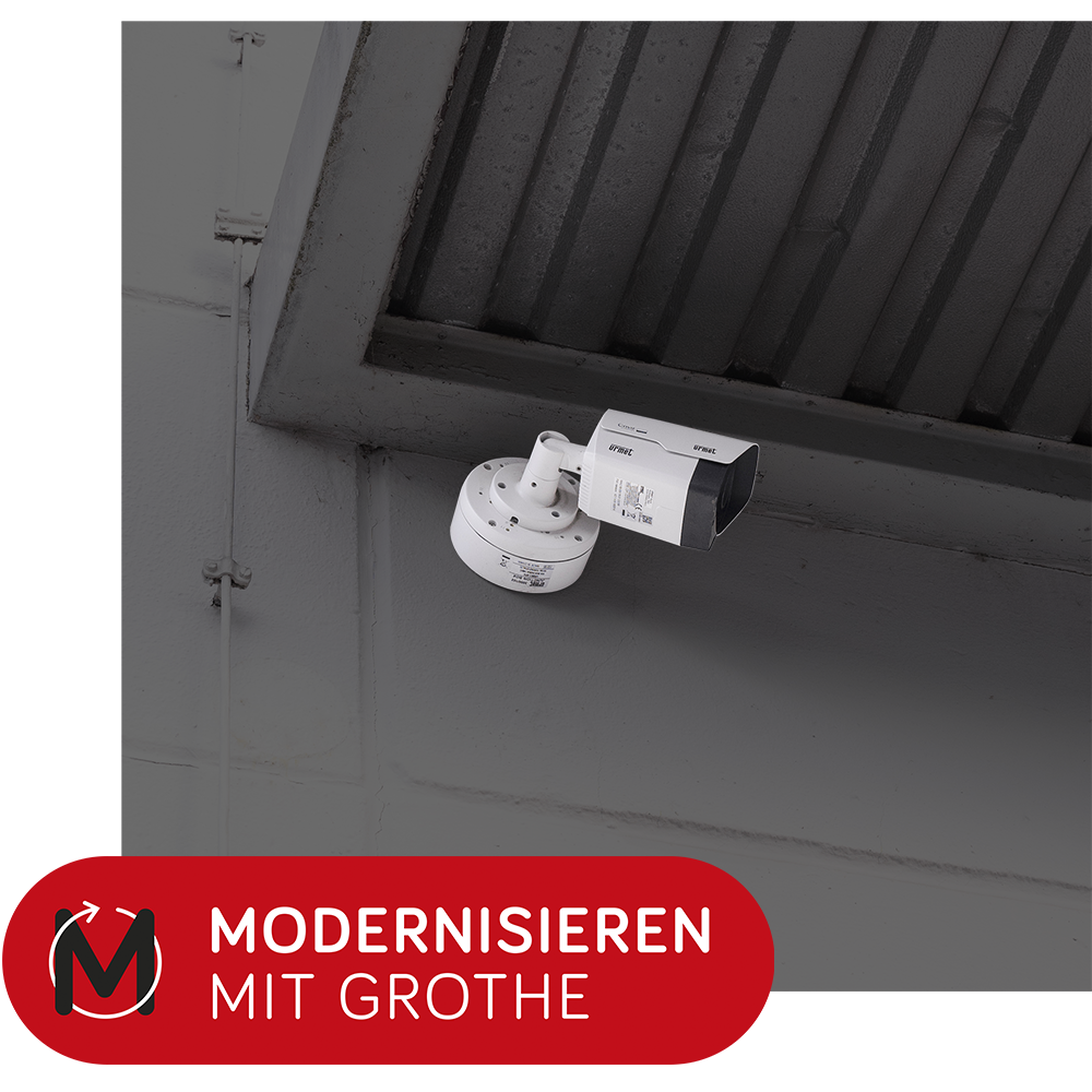 Bullet-Kamera, montiert an einer Außenwand, darauf ein Patch "Modernisieren mit Grothe"