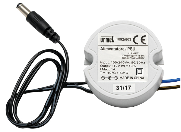 Rundes, weißes Netzteil mit aufgedruckten technischen Daten und festem Kabelanschluss