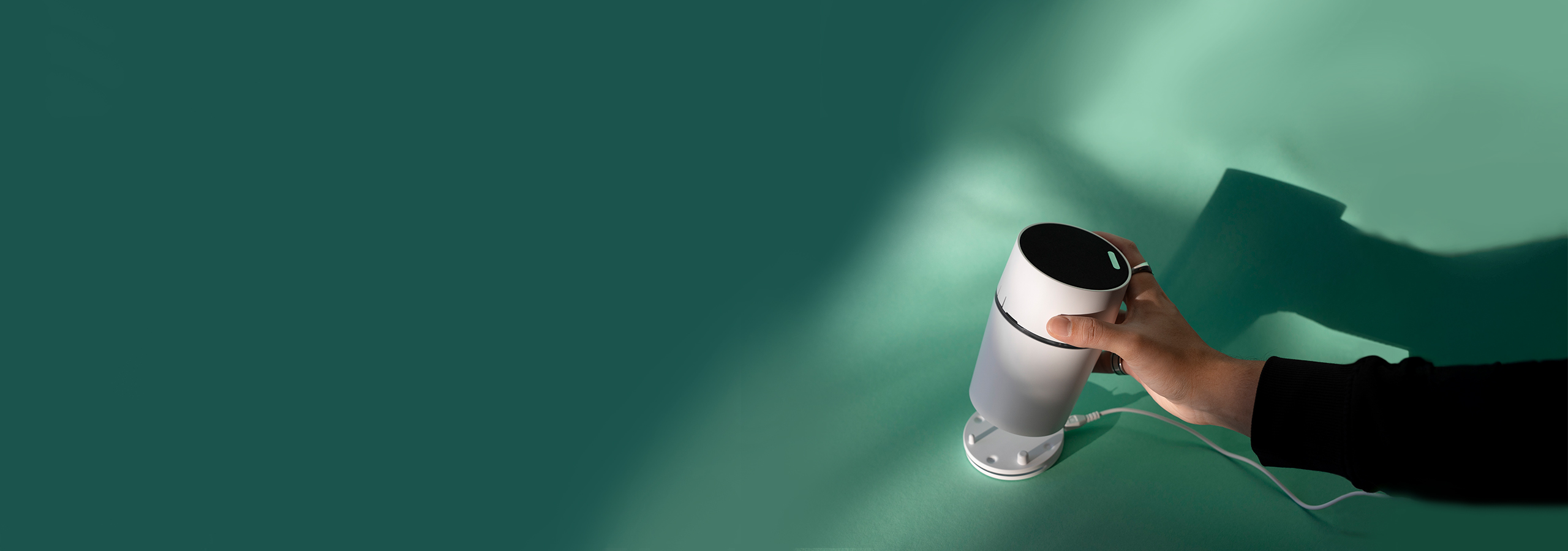 Eine Hand stellt den Funkgong CALIMA 800 auf die Ladeschale