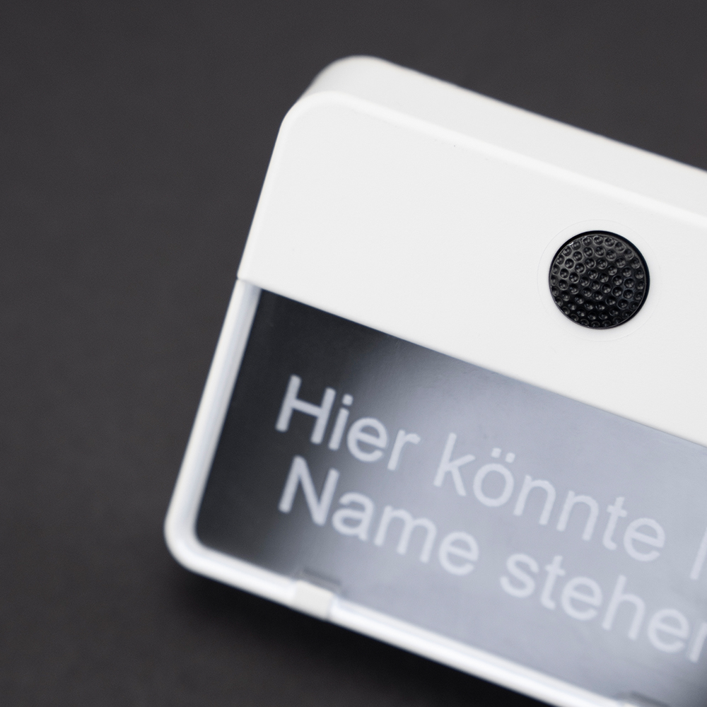 Weißer ETA 651-Klingeltaster auf schwarzem Hintergrund; auf dem Namensschild steht "Hier könnte Ihr Name stehen"