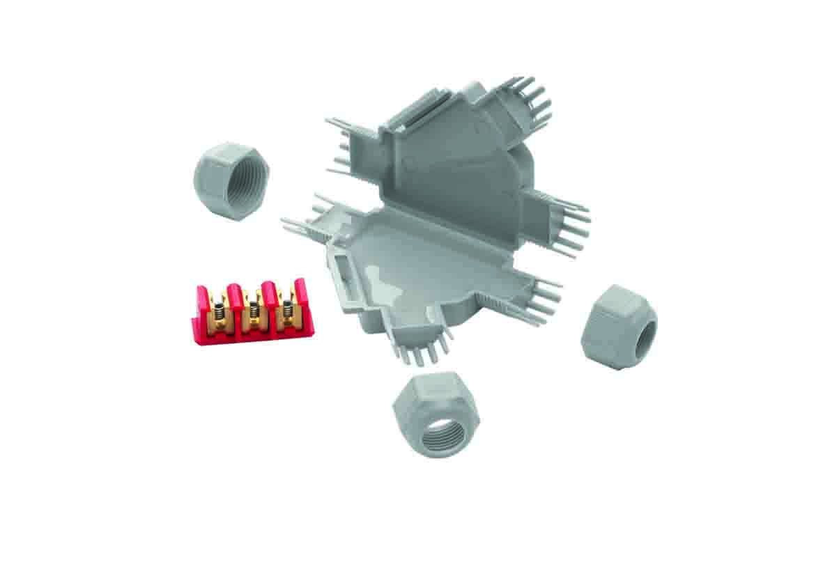 Graue Mikro-Verbindungsmuffe, daneben liegen eine Schraubklemme und Kabelverschraubungen