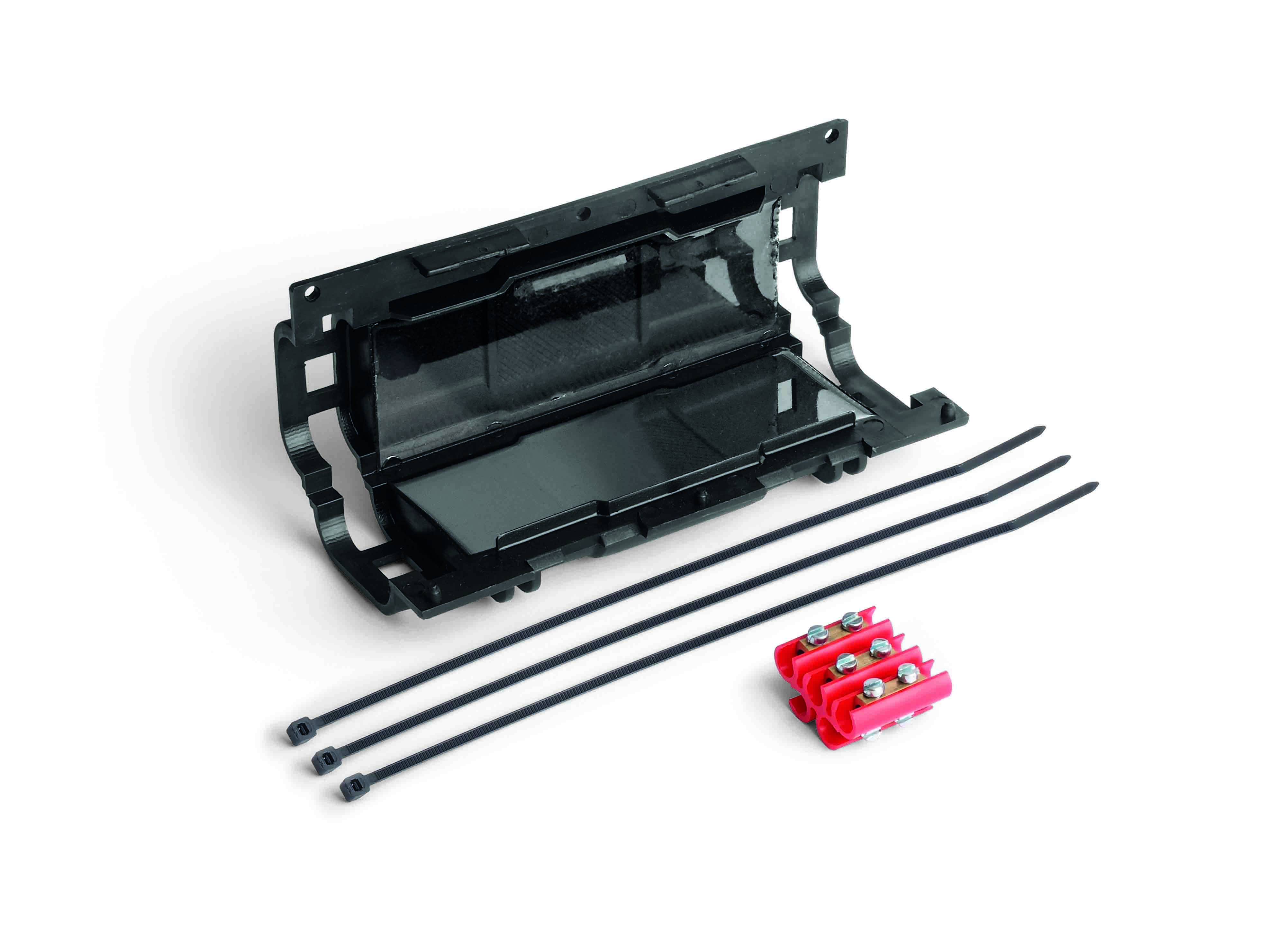 Längliche schwarze Verbindungsmuffe mit Gel gefüllt, halb geöffnet. Davor liegen Klemmleisten und Kabelbinder.