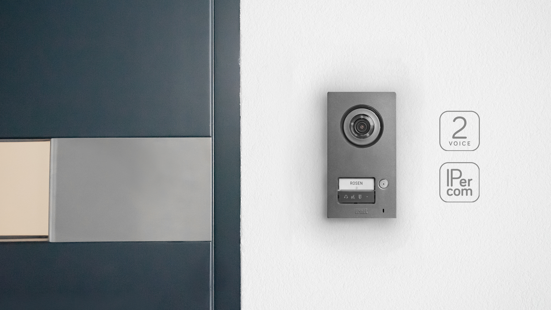 MIKRA Türstation, angebracht an einer Hauswand; daneben sind die Icons für 2Voice und IPercom