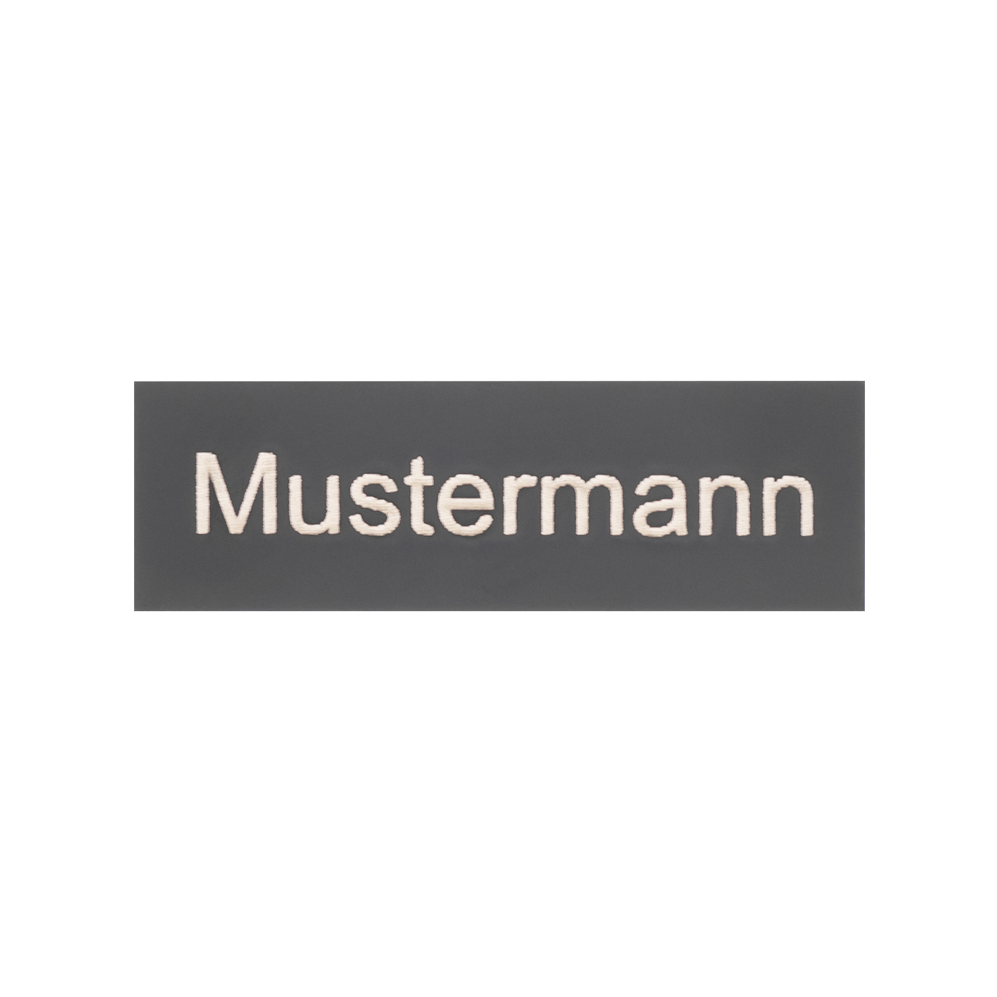 Graues Gravier-Namensschild mit weißer Aufschrift „Mustermann“, zentriert auf rechteckiger Fläche ohne Halterung.