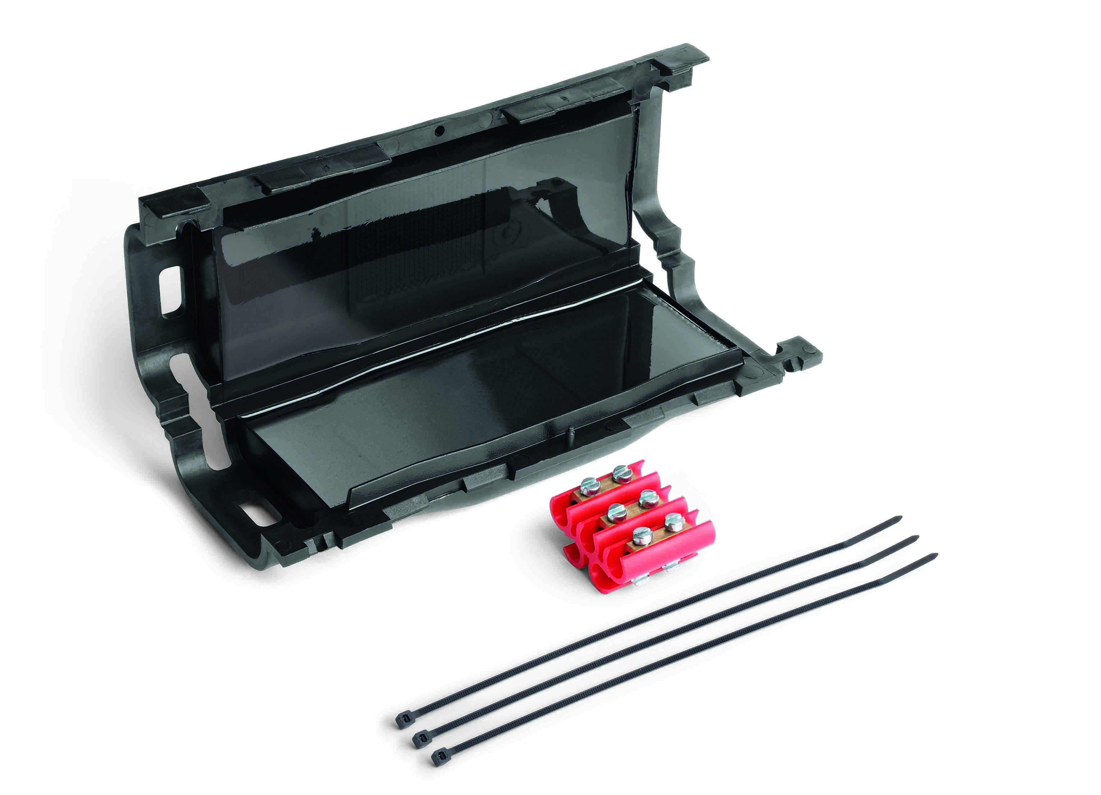 Längliche schwarze Verbindungsmuffe mit Gel gefüllt, halb geöffnet. Davor liegen Klemmleisten und Kabelbinder.