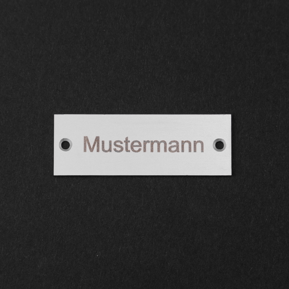 Edelstahl-Gravierschild seitlich liegend; darauf steht "Mustermann"